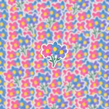 The background is adorned with a vibrant array of colorful flowers featuring blue, pink, and yellow petals, reminiscent of the Flower Bouquet Holographic Sticker. At the center, a more pronounced flower bouquet captures attention, highlighting the floral essence.