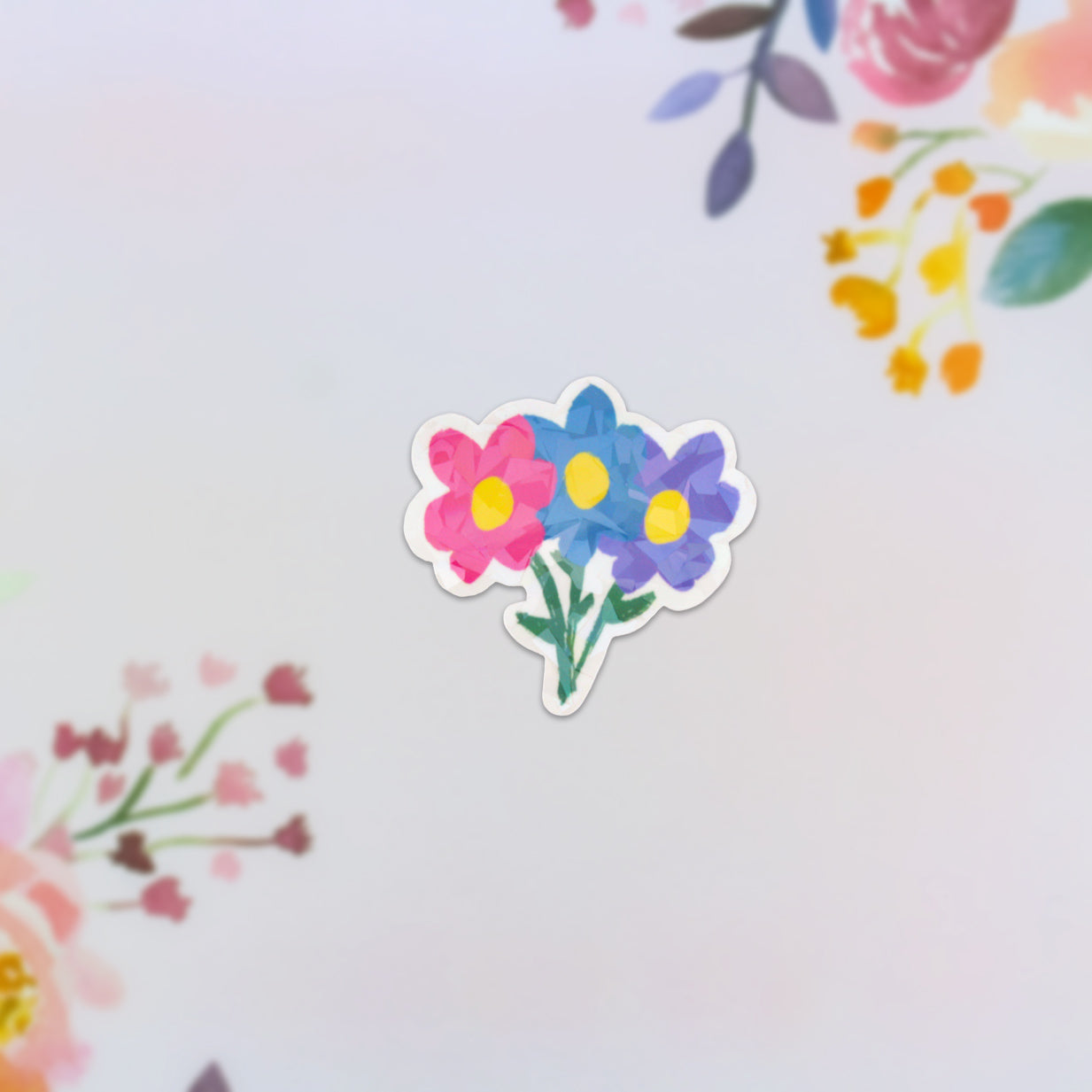 The Flower Bouquet Holographic Sticker showcases a trio of vibrant flowers—pink, blue, and purple—set against a light backdrop with delicate pastel floral accents along the borders.