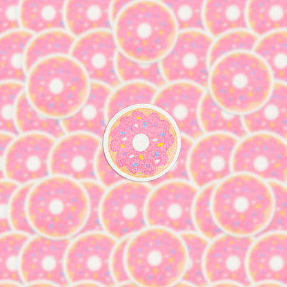 The image is filled with pink frosted donuts adorned with sprinkles, and the central donut is accentuated by a white outline, closely resembling the Strawberry Donut Holographic Sticker, thereby making it distinct among the surrounding treats.